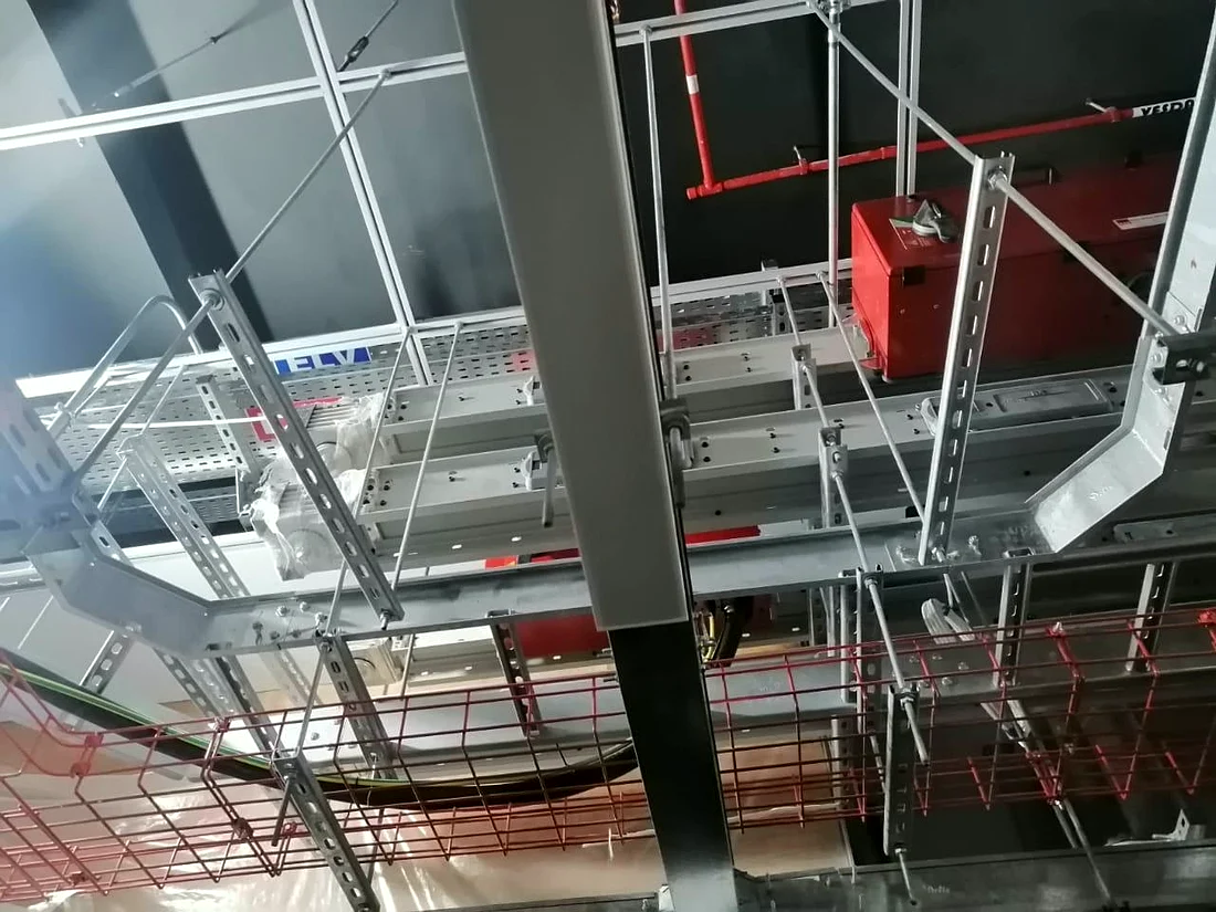 Cable trays, basket containment and a firefighting main set out below the soffit by Mecamac before the ceiling closes